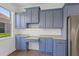 Bright kitchen area showcasing blue cabinetry, light countertops, and a modern stainless steel refrigerator at 4244 Reflections Pkwy, Sarasota, FL 34233