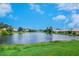 Gorgeous lake surrounded by lush trees, blue sky, and puffy white clouds at 4244 Reflections Pkwy, Sarasota, FL 34233