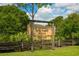 A wooden sign with a rustic fence marks the entrance to Urfer Gathering Park with lush vegetation in the background at 4244 Reflections Pkwy, Sarasota, FL 34233