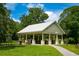 A picnic pavilion featuring a metal roof, stone pillars, trash receptacle and picnic tables surrounded by a green lawn at 4244 Reflections Pkwy, Sarasota, FL 34233