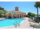 Community pool with lounge chairs and tables, set against a sunny backdrop enhances community appeal at 4244 Reflections Pkwy, Sarasota, FL 34233