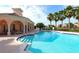 Inviting community pool with clear blue water, surrounded by palm trees and clubhouse at 4244 Reflections Pkwy, Sarasota, FL 34233