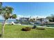 Waterfront condo view with palm tree, green lawn, boats, and blue water at 448 Gulf Of Mexico Dr # A204, Longboat Key, FL 34228