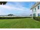 Backyard view showcasing a grassy lawn, lush landscaping, and serene water view at 4722 Independence Dr, Bradenton, FL 34210