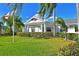 Well manicured lawn in front of the clubhouse featuring American flags and lush vegetation at 4722 Independence Dr, Bradenton, FL 34210