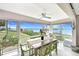 Sunroom dining area with panoramic water views, ceiling fan, and seating for six at 4722 Independence Dr, Bradenton, FL 34210