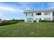 Exterior view of a two-story home with lots of windows on a sprawling lawn at 4722 Independence Dr, Bradenton, FL 34210