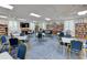 Library with blue accent chairs and tables, lots of book shelves, and a tv with a piano at 4722 Independence Dr, Bradenton, FL 34210