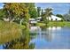 Serene view of a pond from a peaceful community, complete with a covered dock and verdant surroundings at 4722 Independence Dr, Bradenton, FL 34210