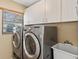 Well-equipped laundry room showcasing modern washer and dryer units and ample cabinet storage at 4768 Tivoli Ave, Sarasota, FL 34235