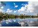 Scenic water view reflecting the blue sky and clouds above the treeline at 4768 Tivoli Ave, Sarasota, FL 34235