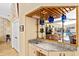 Modern wet bar with granite countertop, glass shelves, and mirrored background, perfect for entertaining guests at 4768 Tivoli Ave, Sarasota, FL 34235