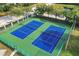 Aerial shot of tennis courts, surrounded by lush greenery, ready for a match at 4802 51St W St # 613, Bradenton, FL 34210