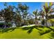 Lush green backyard with palm trees, manicured lawn, and waterfront access at 505 65Th St, Holmes Beach, FL 34217