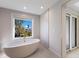 Bright bathroom featuring a modern soaking tub situated next to a window providing ample natural light at 505 65Th St, Holmes Beach, FL 34217