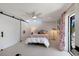 Bright bedroom featuring white walls, skylight, ceiling fan, sliding closet doors, and access to outdoor patio at 505 65Th St, Holmes Beach, FL 34217