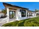 Exterior view of a modern home with a covered outdoor shower, patio, and lush green lawn at 505 65Th St, Holmes Beach, FL 34217