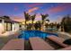 Inviting pool area with lounge chairs and dining set amidst tropical landscaping under a vibrant sky at 505 65Th St, Holmes Beach, FL 34217