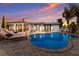 Stunning backyard pool and lounge area with colorful sunset, lush landscaping, and modern architecture at 505 65Th St, Holmes Beach, FL 34217