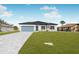 New construction home features light-colored exterior, gray paver driveway, and landscaping at 514 Santiguay St, Punta Gorda, FL 33983