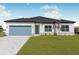 Single-story home with light-colored exterior, gray pavers, and a landscaped lawn at 514 Santiguay St, Punta Gorda, FL 33983