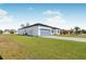 Rear view of a new home with light-colored exterior, gray pavers, and grassy yard at 514 Santiguay St, Punta Gorda, FL 33983