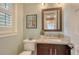 Charming half bathroom featuring a decorative mirror, granite countertop, and light green walls at 515 S Osprey Ave, Sarasota, FL 34236