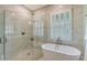 Bright bathroom showcasing a glass-enclosed shower, soaking tub, and plantation shutters on the window at 515 S Osprey Ave, Sarasota, FL 34236