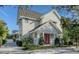 A beautiful two-story home showcases its bright exterior, striking red door, and lush, mature landscaping at 515 S Osprey Ave, Sarasota, FL 34236