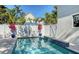 Backyard pool area with a waterfall feature, a white fence, lush trees, and tasteful landscaping at 515 S Osprey Ave, Sarasota, FL 34236