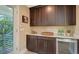 Serving area with dark wood cabinets, light countertops, and a wine cooler with views of the surrounding foliage at 515 S Osprey Ave, Sarasota, FL 34236