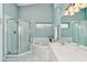 Bright bathroom features a glass-enclosed shower, soaking tub, and modern fixtures at 5251 Mahogany Run Ave # 526, Sarasota, FL 34241