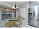 Bright dining nook featuring stainless steel refrigerator, a modern chandelier, and natural light at 5251 Mahogany Run Ave # 526, Sarasota, FL 34241