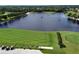 An aerial view displays a lake and driving range with golfers enjoying the course at 5251 Mahogany Run Ave # 526, Sarasota, FL 34241