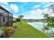 Picturesque backyard view overlooking a serene pond, lush green lawn, and neighboring homes at 5276 Mahogany Run Ave, Sarasota, FL 34241