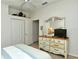 Bedroom featuring wood floors, closet, mirror dresser, and TV at 5276 Mahogany Run Ave, Sarasota, FL 34241