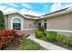 Welcoming home exterior featuring colorful landscaping along walkway leading up to the front door and arched window at 5276 Mahogany Run Ave, Sarasota, FL 34241