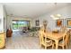 Open-concept living room featuring light wood floors, neutral walls, modern furniture and sliding glass doors to the backyard at 5276 Mahogany Run Ave, Sarasota, FL 34241