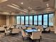 Well-lit meeting room with large windows overlooking serene lake view and neutral-toned chairs surrounding tables at 5276 Mahogany Run Ave, Sarasota, FL 34241