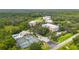 Aerial view of the community, tennis courts, pool, and surrounding landscape at 5300 Manorwood Dr, Sarasota, FL 34235