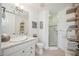 Clean bathroom with white vanity, walk-in shower, and open shelving at 5300 Manorwood Dr, Sarasota, FL 34235