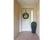 Inviting entryway with a spring wreath and potted plant at 5300 Manorwood Dr, Sarasota, FL 34235