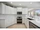 Modern kitchen with white cabinets, quartz countertops and stainless steel appliances at 5300 Manorwood Dr, Sarasota, FL 34235