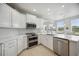 Modern kitchen with white cabinets, quartz countertops, and stainless steel appliances at 5300 Manorwood Dr, Sarasota, FL 34235