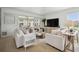 Living room with white sofas, hardwood floors, and a ceiling fan at 5300 Manorwood Dr, Sarasota, FL 34235