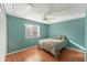 This bedroom features bright teal walls, wood floors, a ceiling fan, and a cozy patterned bed at 5400 34Th W St # A17, Bradenton, FL 34210