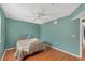 This bedroom features bright teal walls, wood floors, a ceiling fan, and a cozy patterned bed at 5400 34Th W St # A17, Bradenton, FL 34210