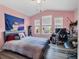 This is a secondary bedroom that is painted pink, has gray floors, and a work desk at 5580 Pleasantview Ct, Lakewood Ranch, FL 34211