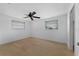 Inviting bedroom featuring dual windows, a ceiling fan, and neutral carpeting at 5630 Saint Louis Ave, Sarasota, FL 34233