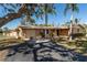 Attractive single-story home with mature trees, a two-car garage and well-manicured lawn at 5630 Saint Louis Ave, Sarasota, FL 34233